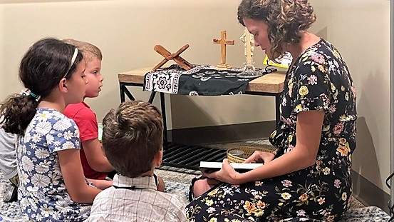 Bible teacher praying during catecheisis